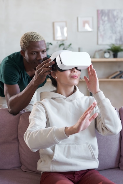 African man setting video game on vr glasses for woman she is going to play virtual reality game