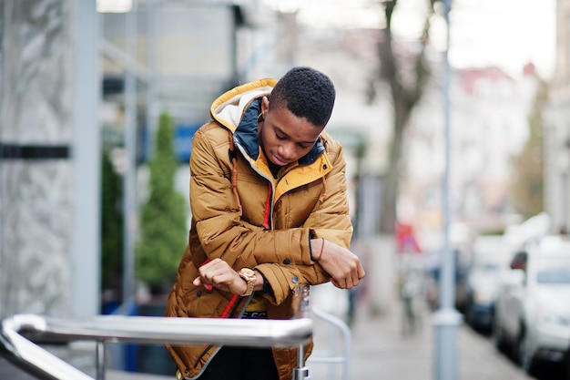 African man wear on orange jacket at cold weather posed outdoor