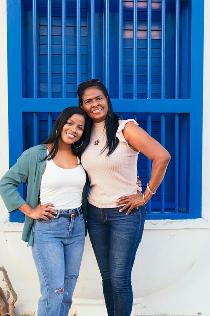 African mother and daughter standing together in the street