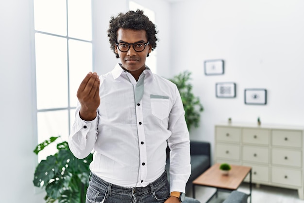 African psychologist man at consultation office doing italian gesture with hand and fingers confident expression