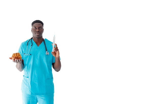 An AfricanAmerican doctor holds a syringe and cakes on a white background The concept