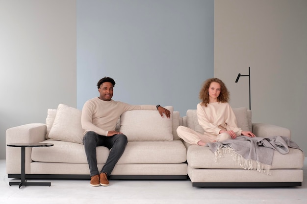 AfricanAmerican man and European woman sit on same couch Young family in modern interior