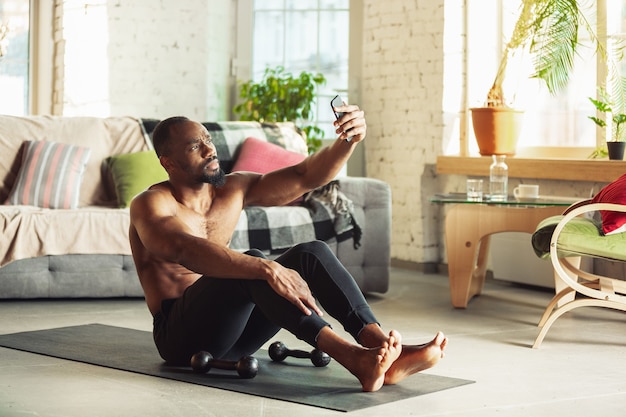 Africanamerican man teaching at home online courses of fitness aerobic sporty lifestyle