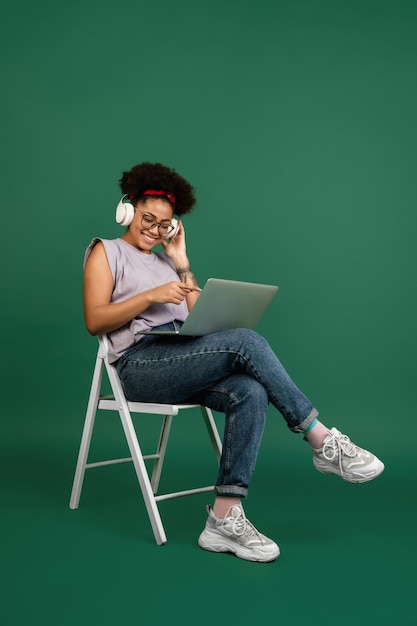 Africanamerican woman's portrait isolated on green studio background with copyspace