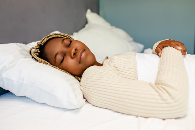 Afro american female keeping eyes closed while sleeping at the bedroom