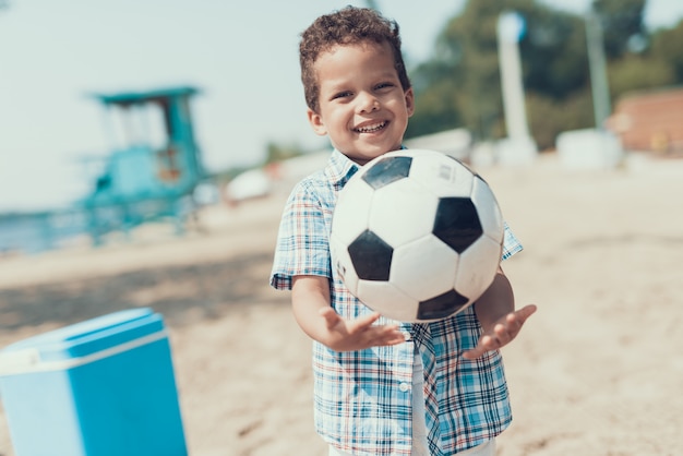 Afro-American Little Boy is Resting on the Beach