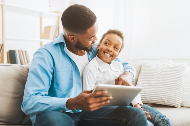 Afro father and daughter ordering clothes and toys on tablet