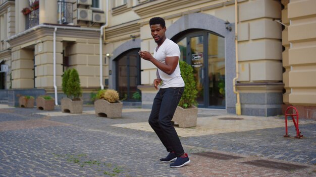 Afro guy dancing latino dance on street Male dancer making body moves in city