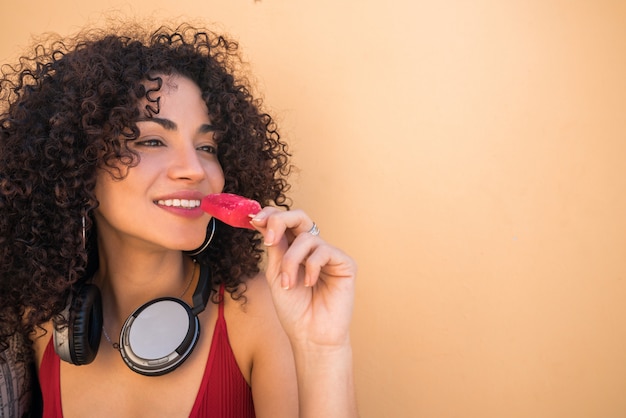 Afro woman enjoying summertime and eating an ice-cream