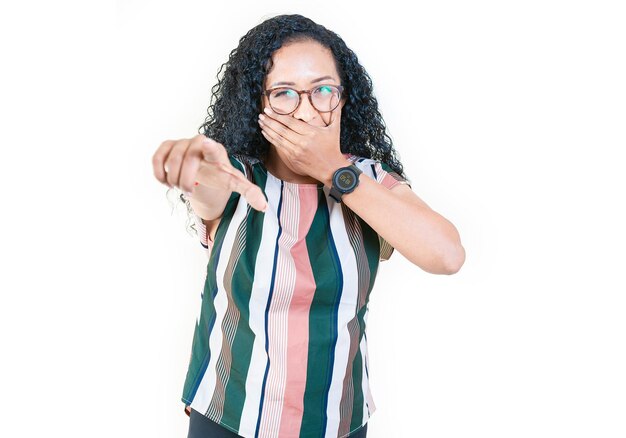 Afro woman laughing at you pointing at the camera isolated Young afro woman mocking and laughing at you isolated