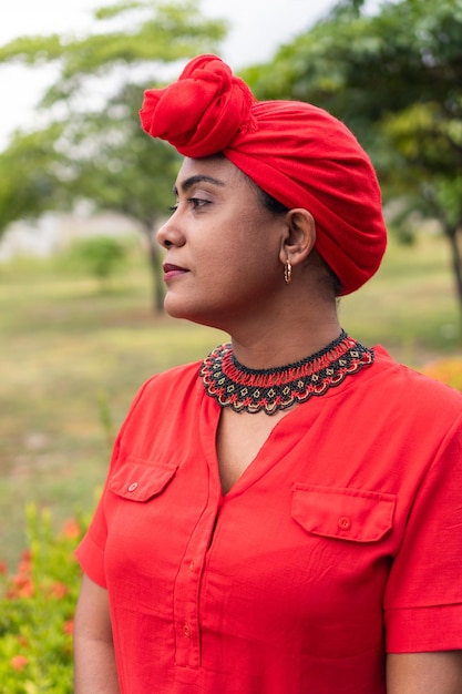 Afro woman looking to the side with a turban in park