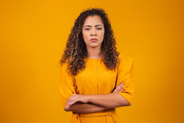 Afro woman with arms crossed on yellow background