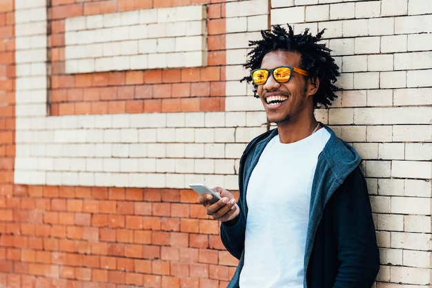 Afro young man using mobile phone bicycle.