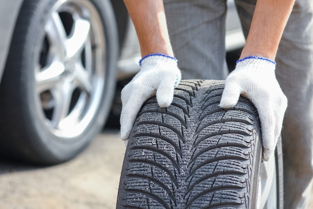 A After a breakdown, a person changes a wheel on a car