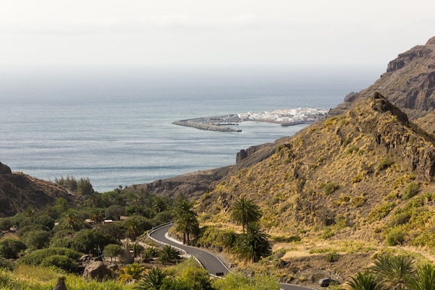 Photo agaete fishing town views from top of mountain in gran canaria road leading to puerto de las nieves