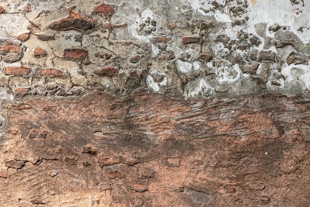 Aged abandoned brick wall with destroyed plaster