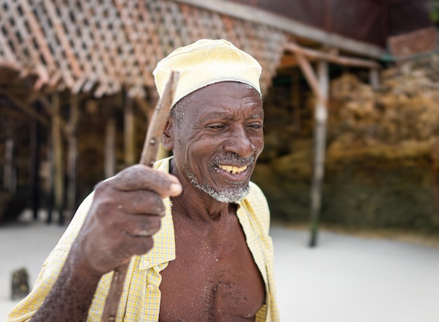 Aged african shepard walking on the beach holding stick