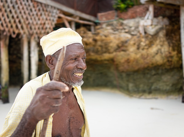 Aged african shepard walking on the beach holding stick