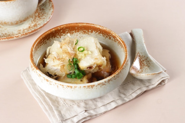 Agedashi is Fried Tofu Served in Warm Dashi Broth and Garnish with grated ginger, chopped scallions.