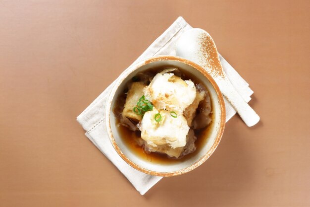 Agedashi is Fried Tofu Served in Warm Dashi Broth and Garnish with grated ginger, chopped scallions.