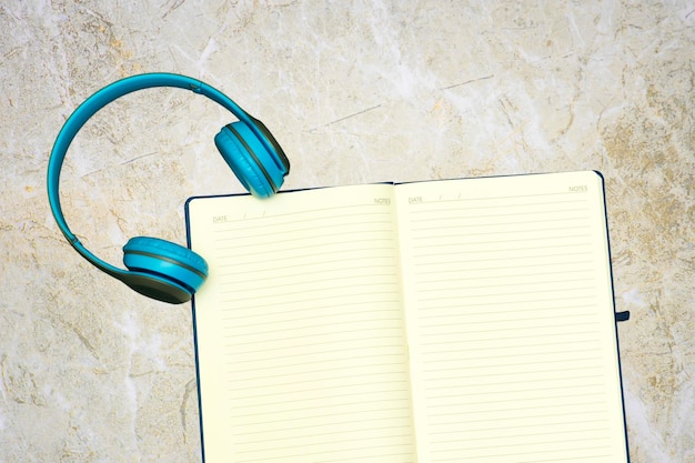 agenda book or notebook and headphone on marble background