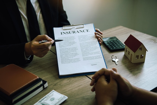 Agents are using pens pointing to insurance contracts and are being explain