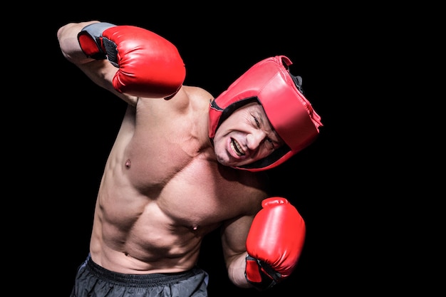 Aggressive boxer puching against black background