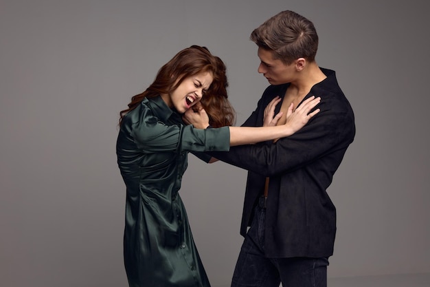 Aggressive woman and strict man on a gray background of conflict misunderstanding High quality photo