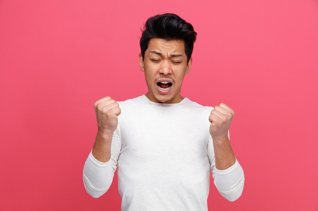 Aggressive young man doing yes gesture with closed eyes 