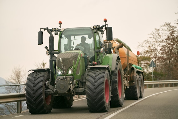 Photo agricultural efforts in motion a tractor at work on a sunny summer day farm tractor moving on the rural road near the farm