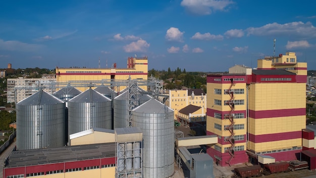 Agricultural Silo Storage and drying of grains wheat corn soy against the blue sky with clouds