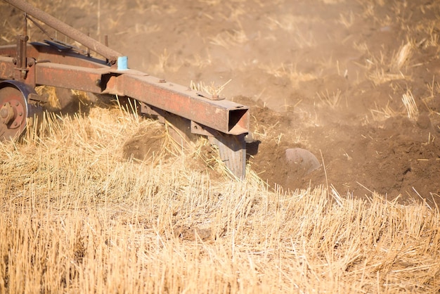 Agriculture blue tractor plowing in autumn on the field