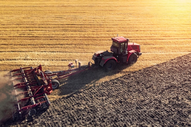 Agriculture machine harvesting crop in fields Tractor pulls a mechanism for haymaking Harvesting in autumn in the morning at dawn agribusiness in the Altai region Russia