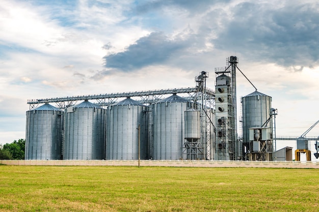 Agroprocessing plant for processing and silos for drying cleaning and storage of agricultural products flour cereals and grain with beautiful clouds