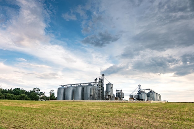 Agroprocessing plant for processing and silos for drying cleaning and storage of agricultural products flour cereals and grain with beautiful clouds