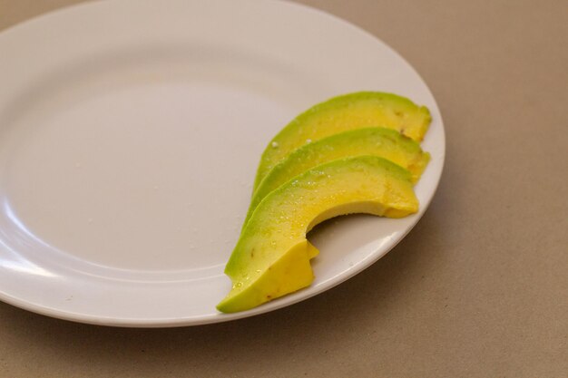 Aguacate fresco cortado en un plato blanco.