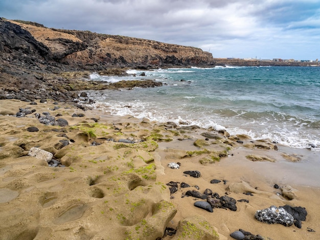 Photo aguadulce beach with golden sand and stones in grand canary island