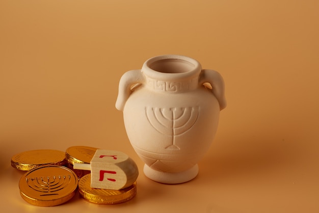 Ah gelt or money or coins with hanukkah dreidel and a hanukkah clay jug  translation happy holidays p