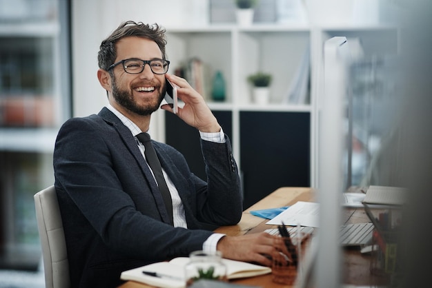 Ah thats just the good news Ive been expecting Shot of a young businessman talking on a cellphone while working in an office