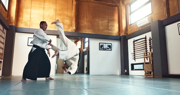 Aikido fight and sensei master in martial arts with training of student in self defence or discipline Class demonstration and Japanese man with black belt in fighting for education of skill