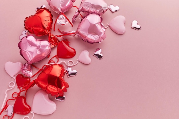 Air balloons of heart shaped foil on pink background love concept valentines day