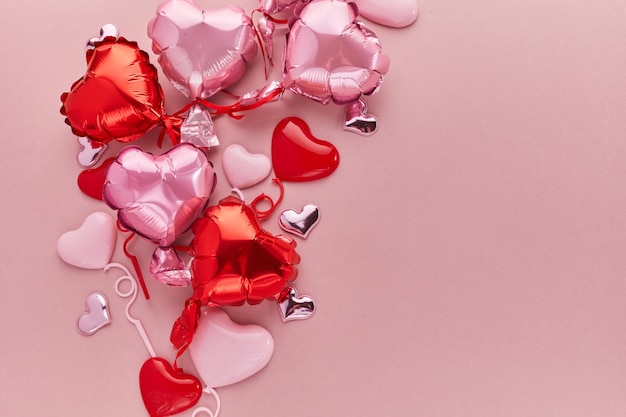 Air balloons of heart shaped foil on pink background love concept valentines day