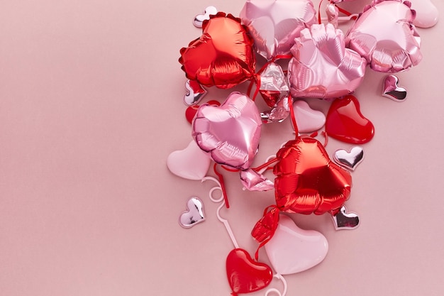 Air balloons of heart shaped foil on pink background love concept valentines day