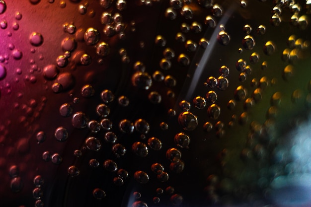 Air bubbles on a piece of ice in a liquid soda. carbonated water in a glass is close