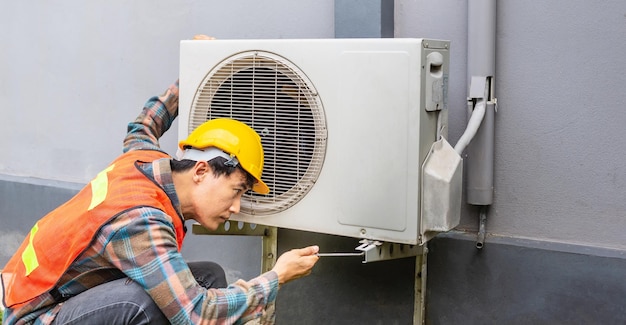 Air conditioner technician Uses wrench to tighten the nut  checking an outside air conditioner unit