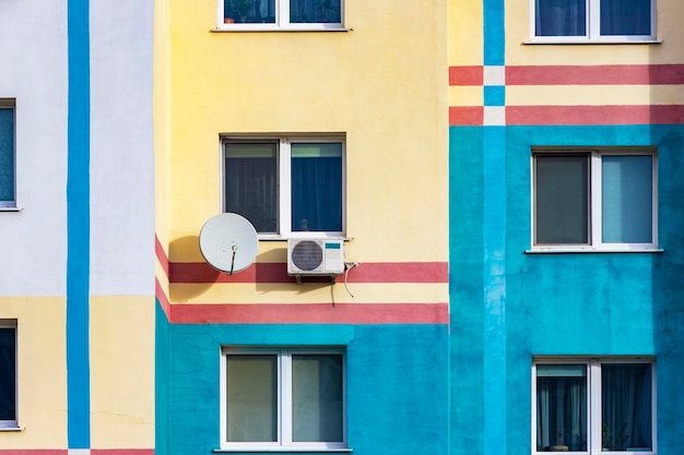 An air conditioning system installed outside on the wall of a multistory building satellite dish Ventilation and air conditioning of housing TV signal