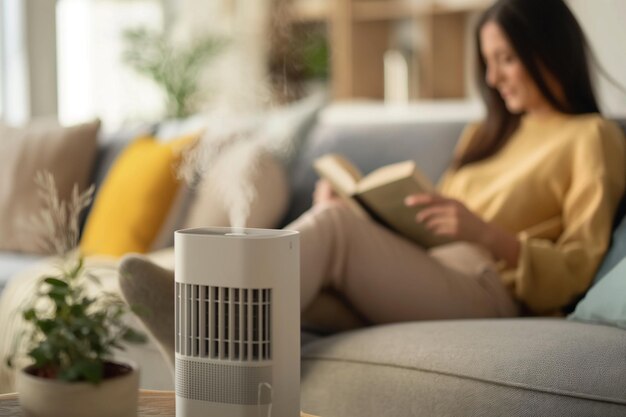 air purifier against blurred woman reading a book on the sofa enhance your reading experience