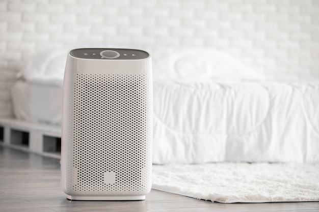 Air purifier in cozy white bed room for filter and cleaning removing dust PM2.5 HEPA in home