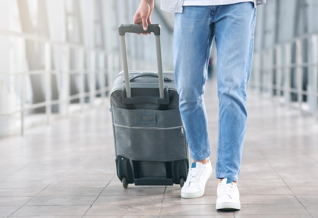 Air travelling concept man walking with luggage at airport corridor