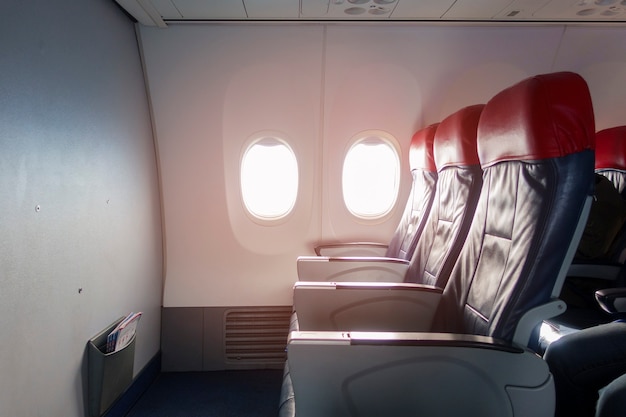 An aircraft cabin with empty passenger rows of seats.